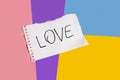 word love on white torn piece of paper on colored paper