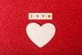Word love on wooden cubes and wooden heart shape on red background, flat lay. Love, romance, relationship concept Royalty Free Stock Photo