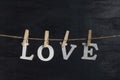 Word LOVE from wooden letters with clothespins on black background Royalty Free Stock Photo
