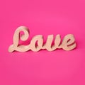 Word love, wooden letters on pink paper. Valentine& x27;s day background. Lovestory or wedding decor.