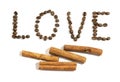 The word love writen with cinnamon stick and coffee beans on white background