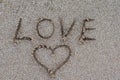 The word love is written with a finger in the sand on a beach. Royalty Free Stock Photo