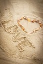 Word love written on sand at beach, heart of shells Royalty Free Stock Photo