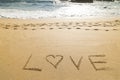 Word love written in the sand of a beautiful beach Royalty Free Stock Photo