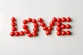 The word love is written on a white background with red beads Royalty Free Stock Photo