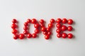 The word love is written on a white background with red beads Royalty Free Stock Photo