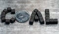 The word lumps of coal laid out on a gray background by cubes with a jar of charcoal black cream Royalty Free Stock Photo