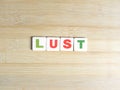 Word Lust on wood background