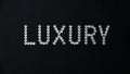 Word Luxury made of shiny white swarovski crystals placed on black leather