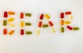 Word made from gummy bears. word bear made of multi-colored gelatinous candies. edible vitamin word. delicious high-calorie