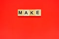 Word make. Top view of wooden blocks with letters on red surface Royalty Free Stock Photo