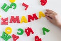 The word MAMA is made of colored magnetic letters typed by a child& x27;s hand. Mother& x27;s day. Kids love mom