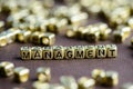 Word MANAGEMENT made from small golden letters on the brown back Royalty Free Stock Photo