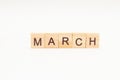 Word MARCH made of wooden blocks on white background. Month of year