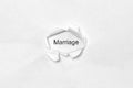 Word Marriage on white isolated background through the wound hole in the paper.