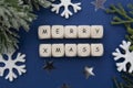 Word Merry Christmas written on wooden cubes over blue background with winter decoration, Christmas background