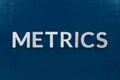 The word metrics laid with silver metal letters on classic blue surface Royalty Free Stock Photo