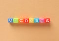 Word Microbes made with colorful cubes on color background, flat lay