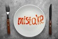 Word MISTAKE written with sauce on plate, top view