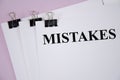 The word mistake written on white piece of paper and pink background