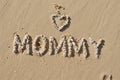 Word MOMMY and a heart made of white little stones on the beach sand, generative ai Royalty Free Stock Photo