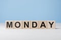 Word Monday on wooden cubes. Weekday concept. Monday inscription on wooden cubes on blue background. copy space