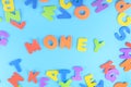 The word Money is made of multicolored letters. Bright inscription on a blue background.