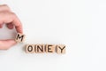 The word MONEY spelled out in wooden letter tiles.