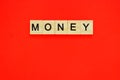 Word money. Top view of wooden blocks with letters on red surface Royalty Free Stock Photo