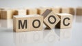 word MOOC on wooden cubes, gray background