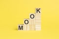 word MOOC on wooden cubes, yellow background. MOOC - short for MASSIVE OPEN ONLINE COURSE. Selective focus.
