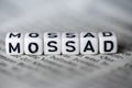 Word MOSSAD formed by wood alphabet blocks on newspaper