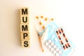 The word MUMPS is made of wooden cubes on a white background. Medical concept