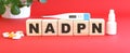 The word NADPH is made of wooden cubes on a red background. Medical concept. Royalty Free Stock Photo