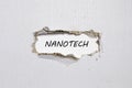 The word nanotech appearing behind torn paper