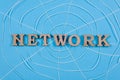 The word network with wooden letters in the form of an abstract spider web, blue background Royalty Free Stock Photo