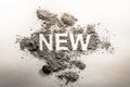 Word new written in ash, dust, dirt as a irony, oxymoron, paradox concept for old, news, business, sale, death, life, future, adv Royalty Free Stock Photo