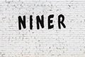 Word niner painted on white brick wall Royalty Free Stock Photo
