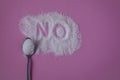 Word NO hand written on a heap of white sugar with full teaspoon of sugar on a pink background top view. Royalty Free Stock Photo