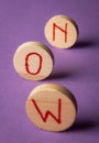 Word now on wooden pieces. Seize the moment. Purple background