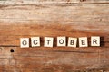 The word october is written in wooden letters on a wooden background. Autumn concept and calendar concept. Copy space
