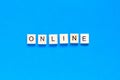 Word Online made with wooden letterpress cubes on blue background. ONLINE written on wood cubes. Conceptual. Expanding business