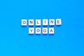 The word ONLINE YOGA written in wooden letterpress type on a blue background. flat layout. top view Royalty Free Stock Photo