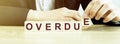 Word OVERDUE made with wood building blocks and business man in suit Royalty Free Stock Photo