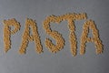 The word pasta written in macaronis on grey background Royalty Free Stock Photo