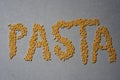 The word pasta written in macaronis on grey background Royalty Free Stock Photo