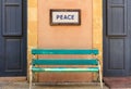 Word peace framed above an old wooden bench on a column. Close up view.