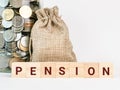 Word pension on wooden cubes with sack of coins against white background. Royalty Free Stock Photo