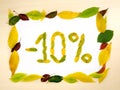 Word 10 percent made of autumn leaves inside of frame of autumn leaves on wood background. Ten percent sale. Autumn sale template.