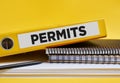 The word permits written on the label of a yellow binder on the office desk Royalty Free Stock Photo